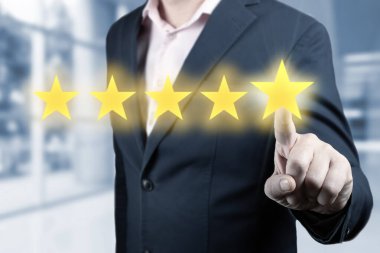 İşadamı beş yıldızlı bir sembole dokunuyor. Adam beş yıldız gösteriyor. Değerlendirme ve değerlendirme konsepti. 5 Yıldızlı Değerlendirme Kişi, Costumer Geribildirim Konsepti - 5 Yıldız Beğeni