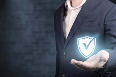 Güvenlik ağı güvenlik bilgisayarı ve veri konseptinizi güvene alın. İş adamı, koyu mavi tuğla duvarda ikonu tutuyor. ticari bilgi güvenliği kavramı