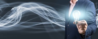 Yanan ampulü tutan iş adamının eli. Yenilikçi teknoloji ve yaratıcılıkla ilgili yeni fikirler. Soyut araştırma geçmişi. kopyalama alanı, afiş