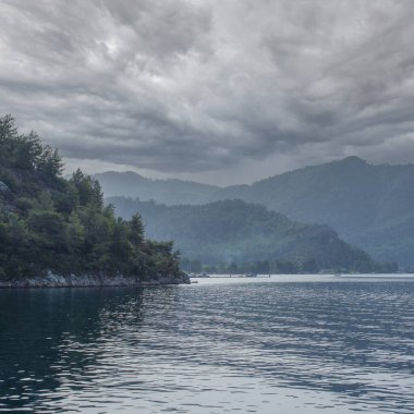 Denizin üzerinde dramatik bir gökyüzü. Bulutlu bir günde dağ manzarası denizi. Deniz manzarası. kare resim resmi