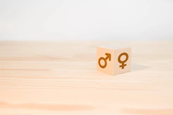 wooden cube with male and female symbols. the concept of gender difference and equality. selection or changing gender. copy space. Male and female gender icons or symbols on two sides of a wooden cube