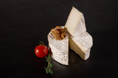 domatesli peynir ve siyah arka planda ceviz. Brie peyniri. Camembert peyniri. Taze Brie peyniri ve taş tahtada bir dilim. İtalyan, Fransız peyniri.