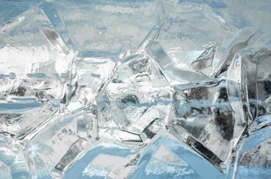 Buz Arkaplanı. Açık mavi bir arkaplanda, çatlamış bir buz bloğundan oluşan dokuların tam çerçevesi. Güzel doğal arka plan. buzun mavi donmuş dokusu