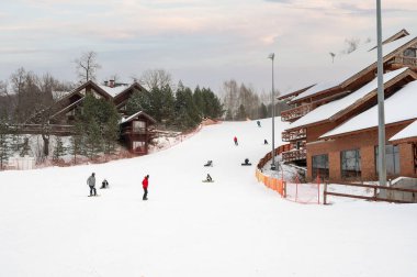 Kazan, Rusya - 3 Ocak 2021: Kazan yakınlarındaki Sviyazhsky Hills tatil köyü. Kayak merkezi manzarası, yamaç, kayak asansöründeki insanlar, beyaz çam ağaçları arasında kayakçılar.