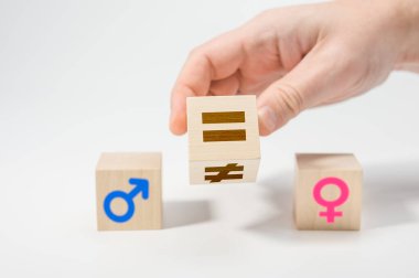Tahta küplerde cinsiyet eşitliği kavramı. Cinsiyet eşitliği kavramları. Eşitsizliğin simgesi olan ahşap küpü eşit işaretle çevirin. beyaz arkaplan