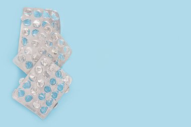 Boş ilaç paketi. Uyuşturucu eksikliği kavramı. Mavi arka planda izole edilmiş boş ilaç paketleri. Sağlık sigortası, tıbbi ilaçlar ve ilaç konsepti. Boşluğu kopyala, üst görünüm