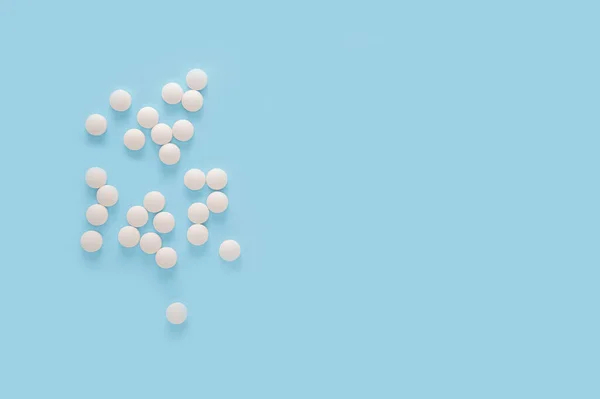 白い丸薬青の背景に隔離された薬 散布薬だ 医薬品の概念 最上階だ コピースペース — ストック写真