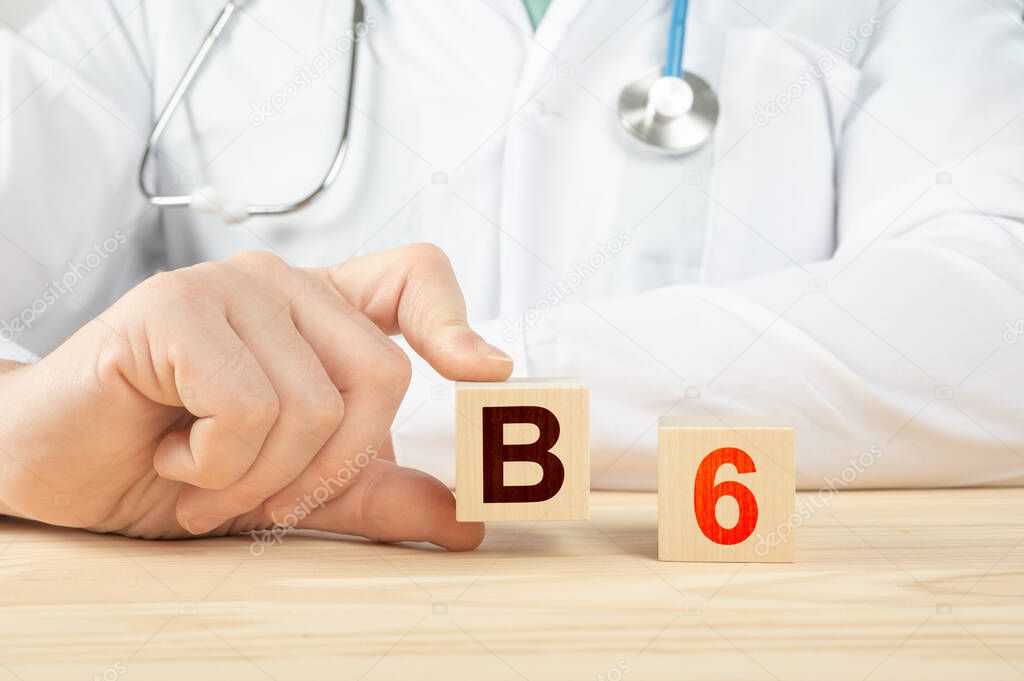 doctor recommends taking vitamin b12. doctor talks about the benefits of vitamin b6. Vitamin - Health Concept. B6 alphabet on wood cube. Hand holds a box of vitamin B6