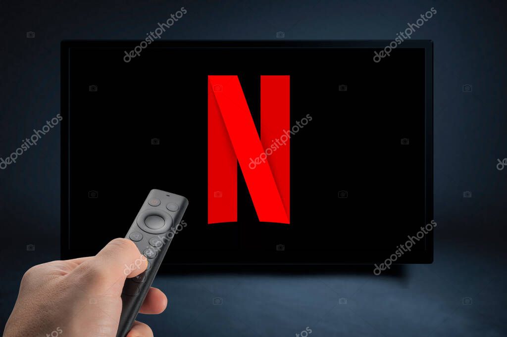 USA, NEW YORK February 2, 2021: Close up of Nvidia Sheild TV Remote in Hand and TV Screen with NEW Netflix Logo, Netflix is a well known global provider of streaming movies and TV series