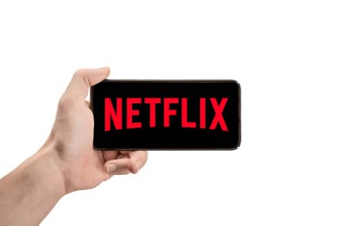 ABD, NEW YORK 2 Şubat 2021: İnsan Eli 'nde NETFLIX logosu olan telefonu kapatın. Yatay konum. Netflix çok iyi bilinen bir film sağlayıcısıdır.