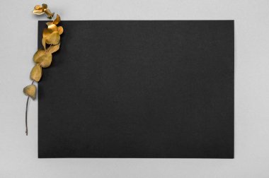 Tarafsız bir masada kurumuş çimen süslemeli siyah davetiye modeli. 5x7 oranı, A4 ve A5 'e benziyor. kopyalama alanı. Minimalist tasarım. İskandinav tarzı