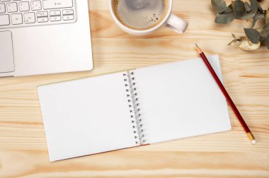 Not defteri maketi, ahşap arka planda kahve, iş yerindeki yazı için en üstte yer var. Üst Manzara. Ahşap masa arkasındaki boş çizim defteri.