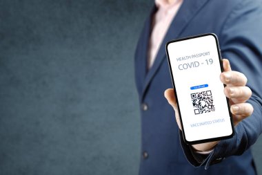 Kapalı 19 Sağlık Pasaportu. Elinde QR kodu covid 19 aşısı olan bir adam var. Cep telefonunda sağlık pasaportu gösteren bir adam var. Bu da Covid-19 'a karşı bir aşı olduğunu gösteriyor.