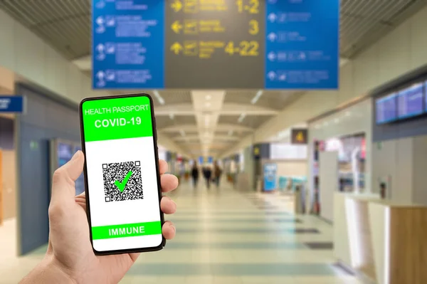 Traveler hand hold phone with health passport of vaccination certification. Health pass on phone at airport have been vaccinated of coronavirus covid-19. Safe travel concept, new normal for travelers