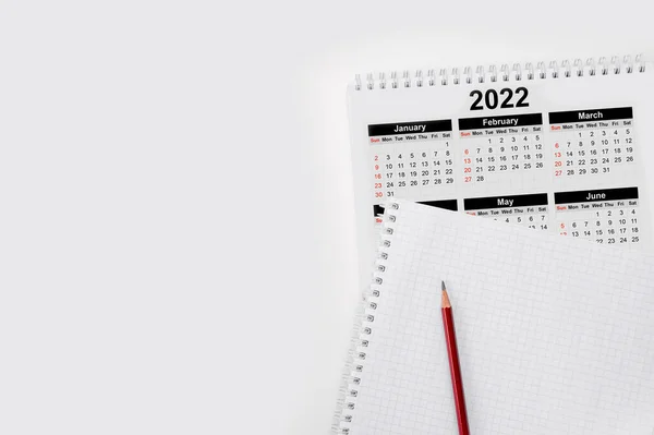 Calendar Year 2022 schedule with blank note for to do list on paper background. Flat lay with calendar, pencil on calander 2022. Close-up of a pencil on the page of a calendar 2022