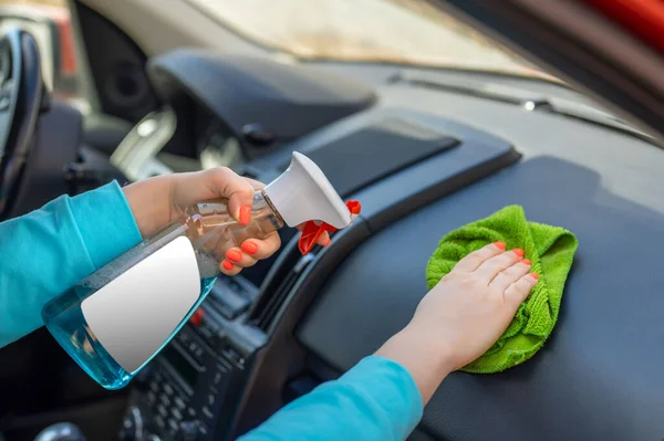スプレーとマイクロファイバーの布で車のコックピットを掃除する女性 スプレーボトルの白いラベル コピースペース — ストック写真