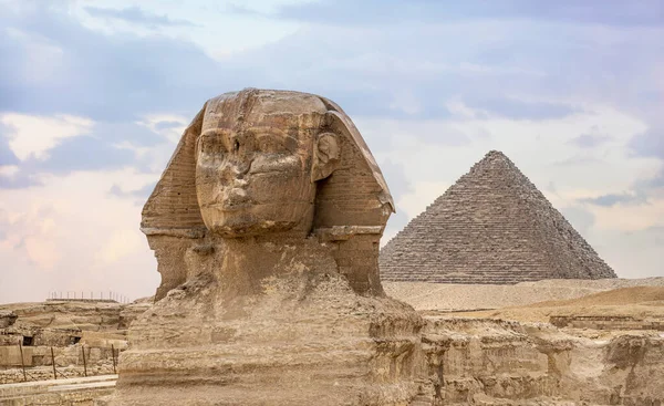 Great Sphinx and Pyramid of Khafre. ancient Egyptian civilization. Landscape with Egyptian pyramids. Ancient symbols and landmarks of Egypt for your travel concept to Africa in golden sunlight.