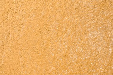 Kum ve su dokusu. Plajdaki altın kumun üzerinde berrak deniz dalgaları. Yaz arkaplanı için kumsaldaki ıslak kum dokusu.