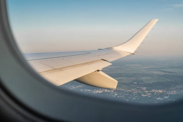 view through the window from cabin of aircraft. Sky scape view from clear glass window seat cabin crew to aircraft wing of plane. International cargo transportation, air travel, transport, air travel