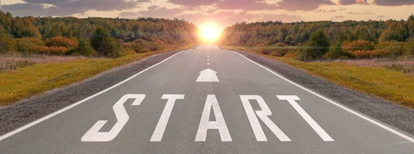 Start written on highway road in middle of empty asphalt road and sunset sky. Start line on highway concept for business planning, strategy and challenge or career path, opportunity and change