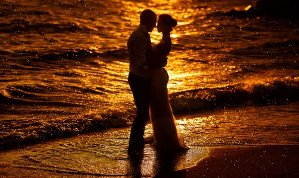 günbatımı su arka plan üzerinde insan siluetleri