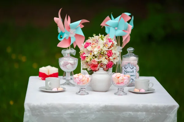 Цветочные композиции и сладости на праздничном столе Стоковое Изображение