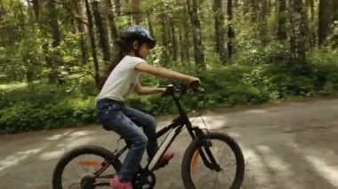 küçük kız onu bisiklet bir orman iz sürmek.