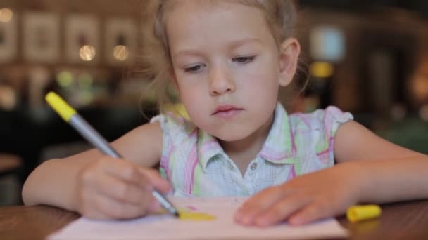 Bambina disegna nel caffè in attesa dell'ordine. bambino in ristorante — Video Stock