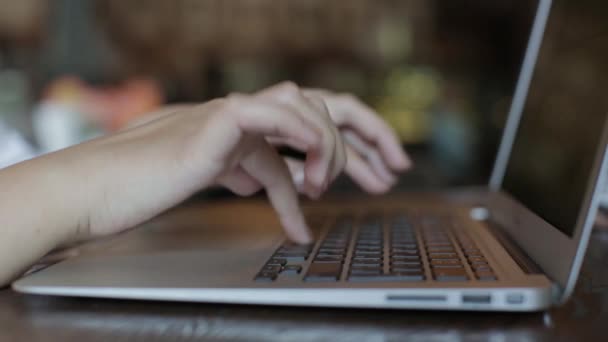 Meisje werkt op laptop zitten in een cafe. Closeup — Stockvideo