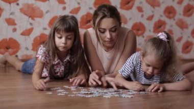 iki küçük kız kardeşim yerde yatarken anne ile bulmacalar toplar