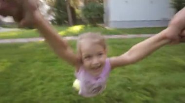 Anne elinde etrafında dönen genç kız çocuk gülümseyen kamera