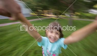 Anne elinde etrafında dönen genç kız çocuk gülümseyen kamera