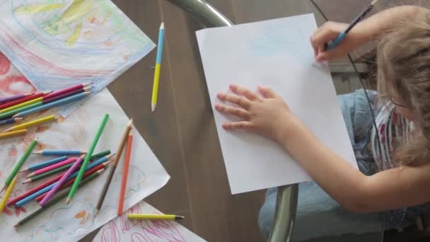 Dos niñas dibujan con lápices de colores sentadas a la mesa. vista superior — Vídeos de Stock