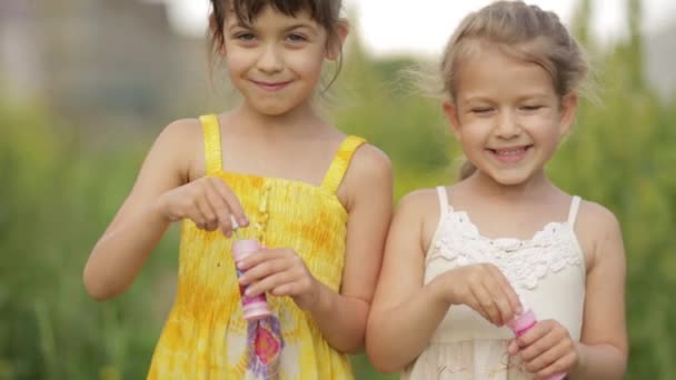 Liten flicka blåser såpbubblor i sommarparken — Stockvideo