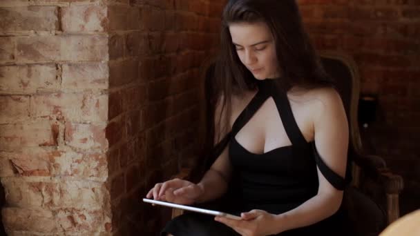 Молодая красивая девушка работает за планшетным компьютером в кафе — стоковое видео
