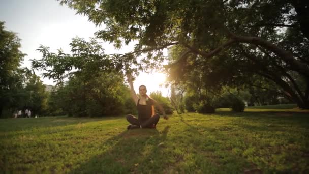 Tanara fata frumoasa face stretching pe iarba în the Park — Videoclip de stoc