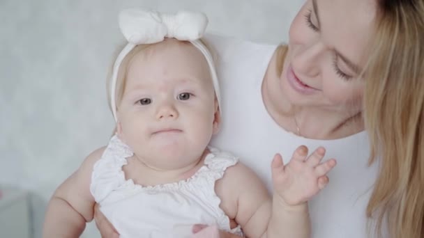 Het kleine meisje maakt haar eerste speech geluiden. Mooie moeder en haar schattige dochter brengen tijd samen door — Stockvideo