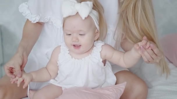 Portret van een schattig klein meisje. Een jonge moeder speelt met haar dochter. Kind blij en glimlachend. Nieuwe ouder met hun baby — Stockvideo