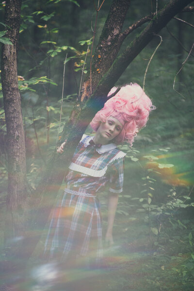 Young sensuality girl posing at forest in pink wig
