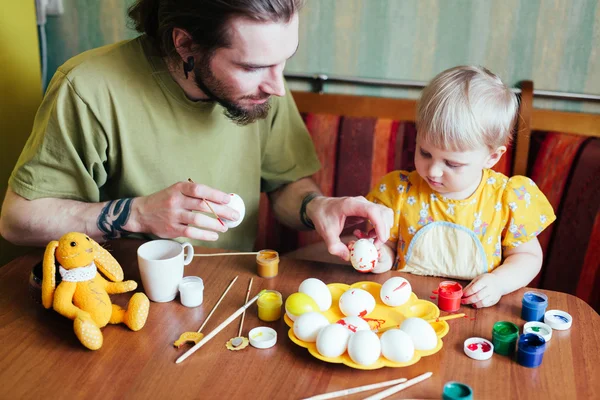 Батько і його дочка малюють великодні яйця . Стокове Зображення
