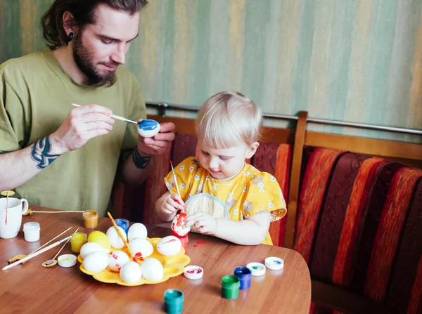 Батько і його дочка малюють великодні яйця . Ліцензійні Стокові Фото