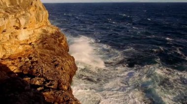 Renkli cliff satırıyla masmavi okyanus ve dalgalar breaking