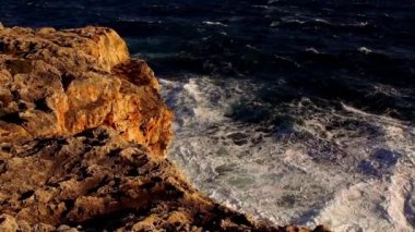 Renkli cliff satırıyla masmavi okyanus ve dalgalar breaking