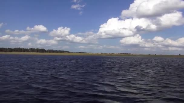 Cabalgando en un hermoso lago en un día soleado — Vídeo de stock