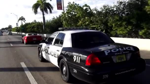 Voiture de police conduisant dans une rue Miami Beach police — Video