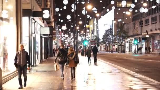 Ανθρώπους που περπατούν μέσα από την Oxford Street, από τη νύχτα στο χρόνο Χριστουγέννων - Λονδίνο, Αγγλία — Αρχείο Βίντεο