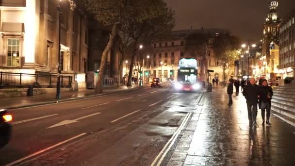 Autobús que llega a la parada de autobús Trafalgar Square por la noche increíble disparo de noche - LONDRES, INGLATERRA — Vídeo de stock