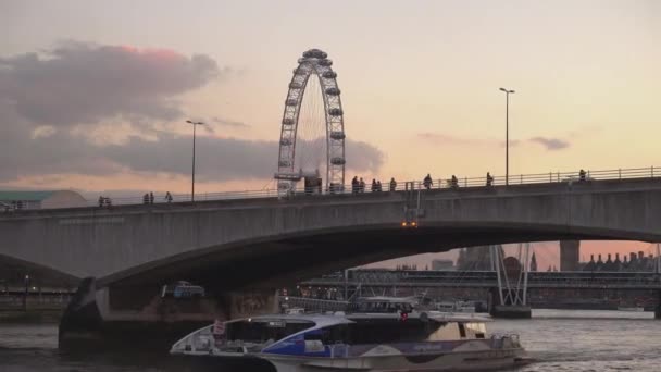 London Eye and Golden Jubilee Bridge in the evening - LONDON, ENGLAND — стоковое видео