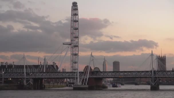 London Eye és a Golden Jubilee híd az esti órákban - London, Anglia — Stock videók