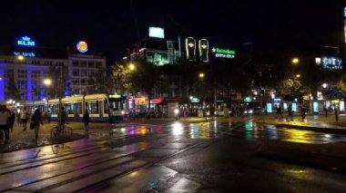 Tramvay gece çıkış ile cadde görünümü Amsterdam